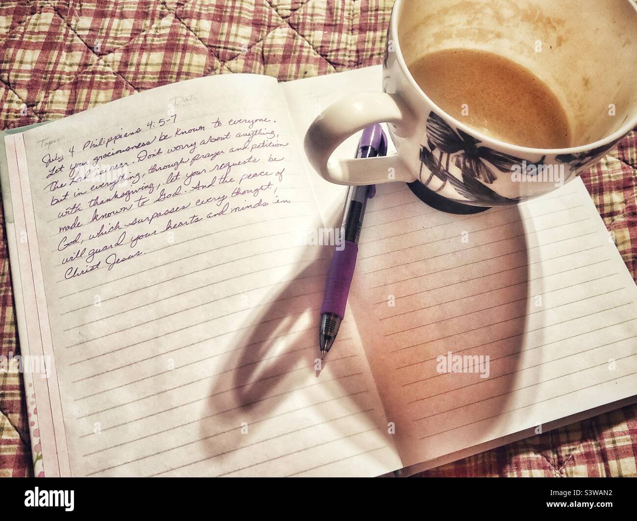 Kaffeetasse auf Bible Journal Stockfoto