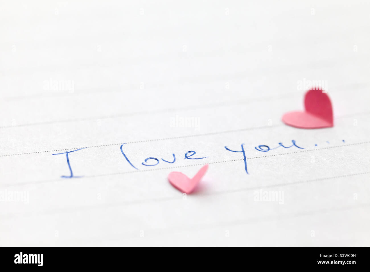 Handgeschriebener Satz Ich liebe dich mit winzigen rosafarbenen Herzen Stockfoto