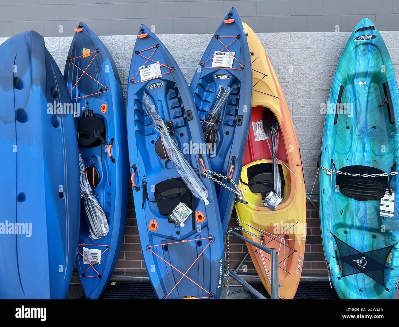 Eine Ausstellung von Kajaks zum Verkauf stützte sich vor einem lokalen Walmart-Laden in Utah, USA. Ein letzter Versuch, Sommerspaß (Produkte) zu verkaufen, während der Sommer sich abwickelt. - Smartphone-aufgenommenes Stockfoto