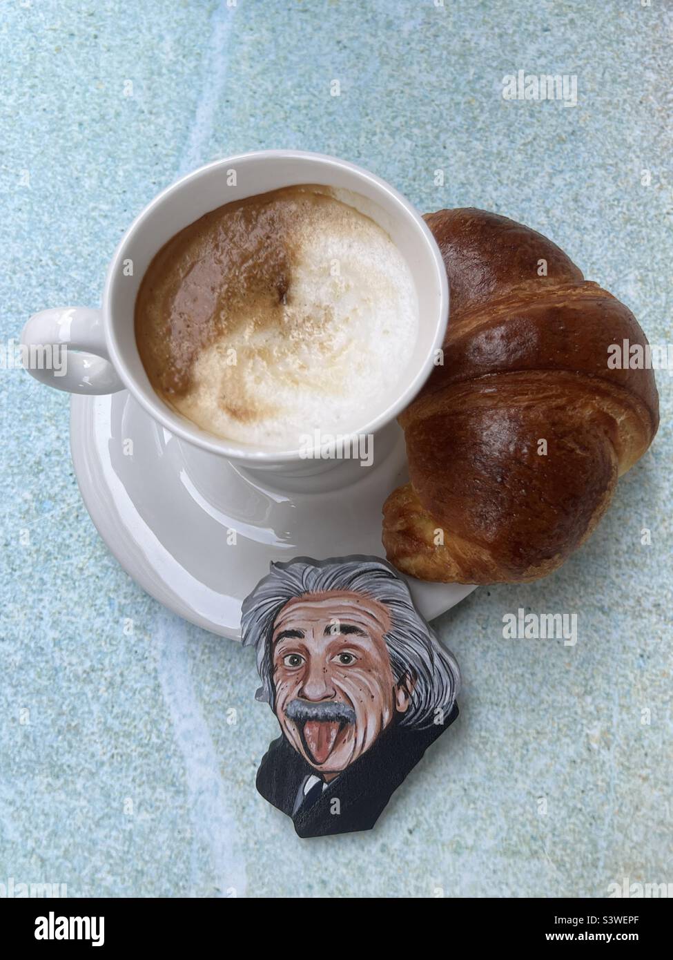 Cleveres Frühstück mit Cappuccino, Croissant und Albert Einstein Stockfoto