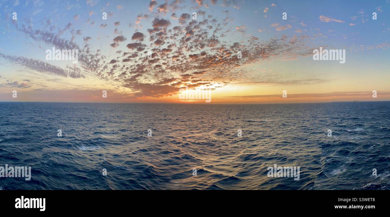 Ein schöner Sonnenuntergang mit einigen Wolken über dem Meer - Smartphone-aufgenommenes Stockfoto
