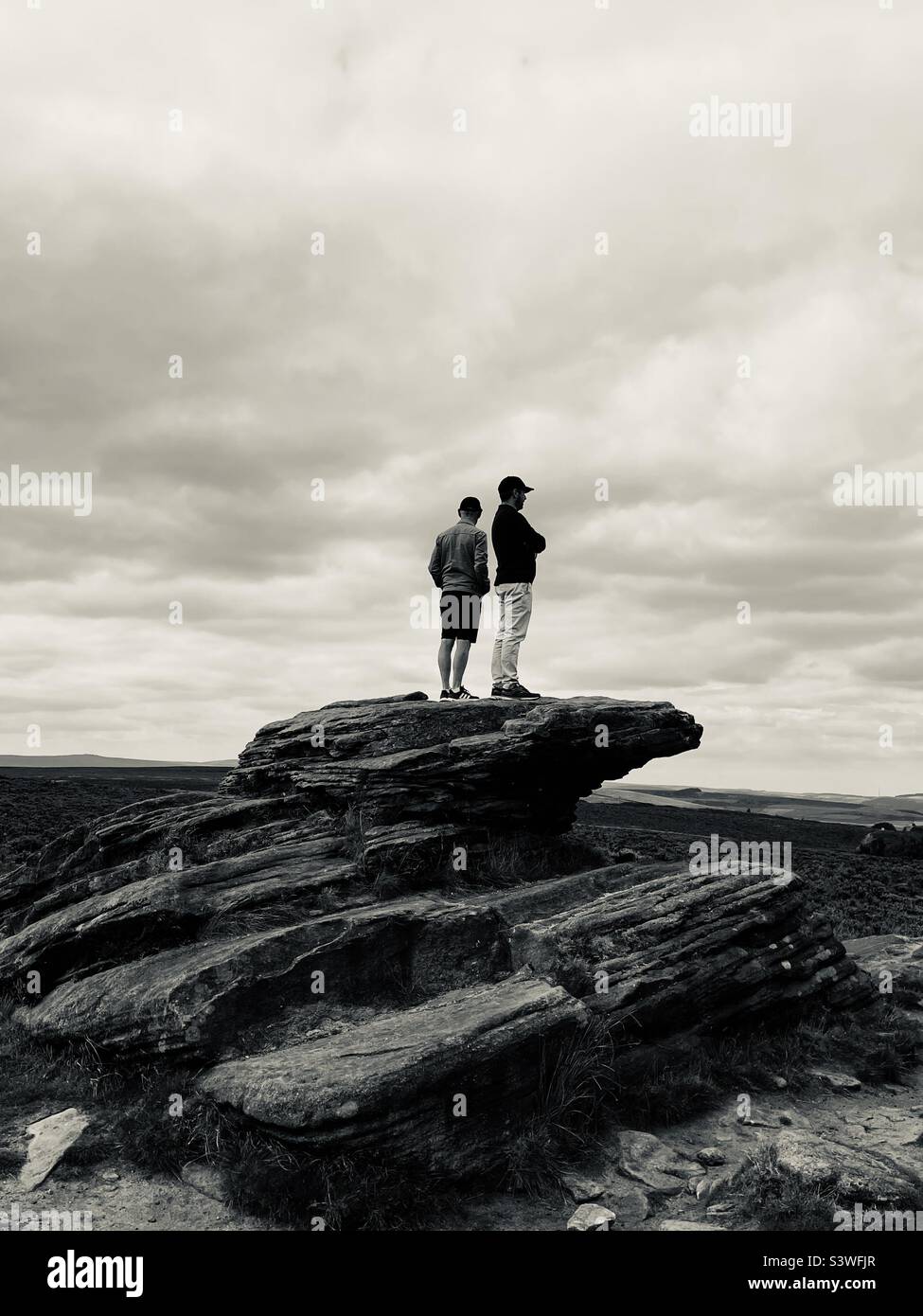Zwei Männer stehen auf einem Felsgipfel Stockfoto