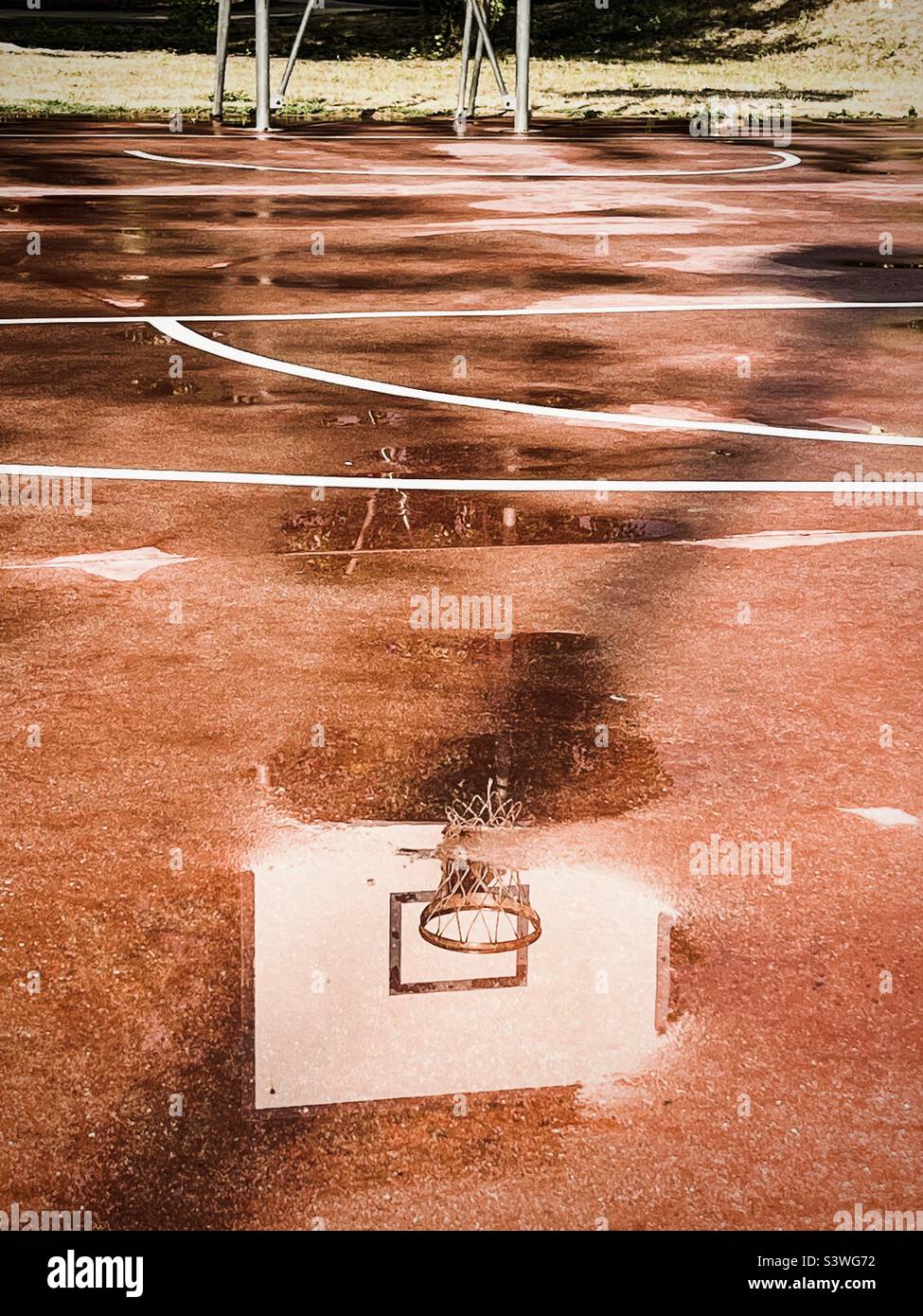 Wasserspiegelung, Pfützen auf dem Basketballplatz Stockfoto