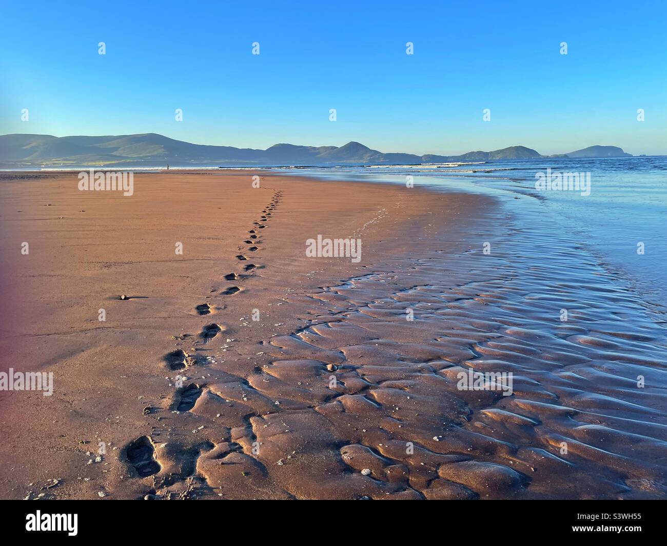 Schritte über den Sand eines eineiigen Angler an der Mündung des Flusses Inny, Grafschaft Kerry, Irland, Ebbe. Stockfoto
