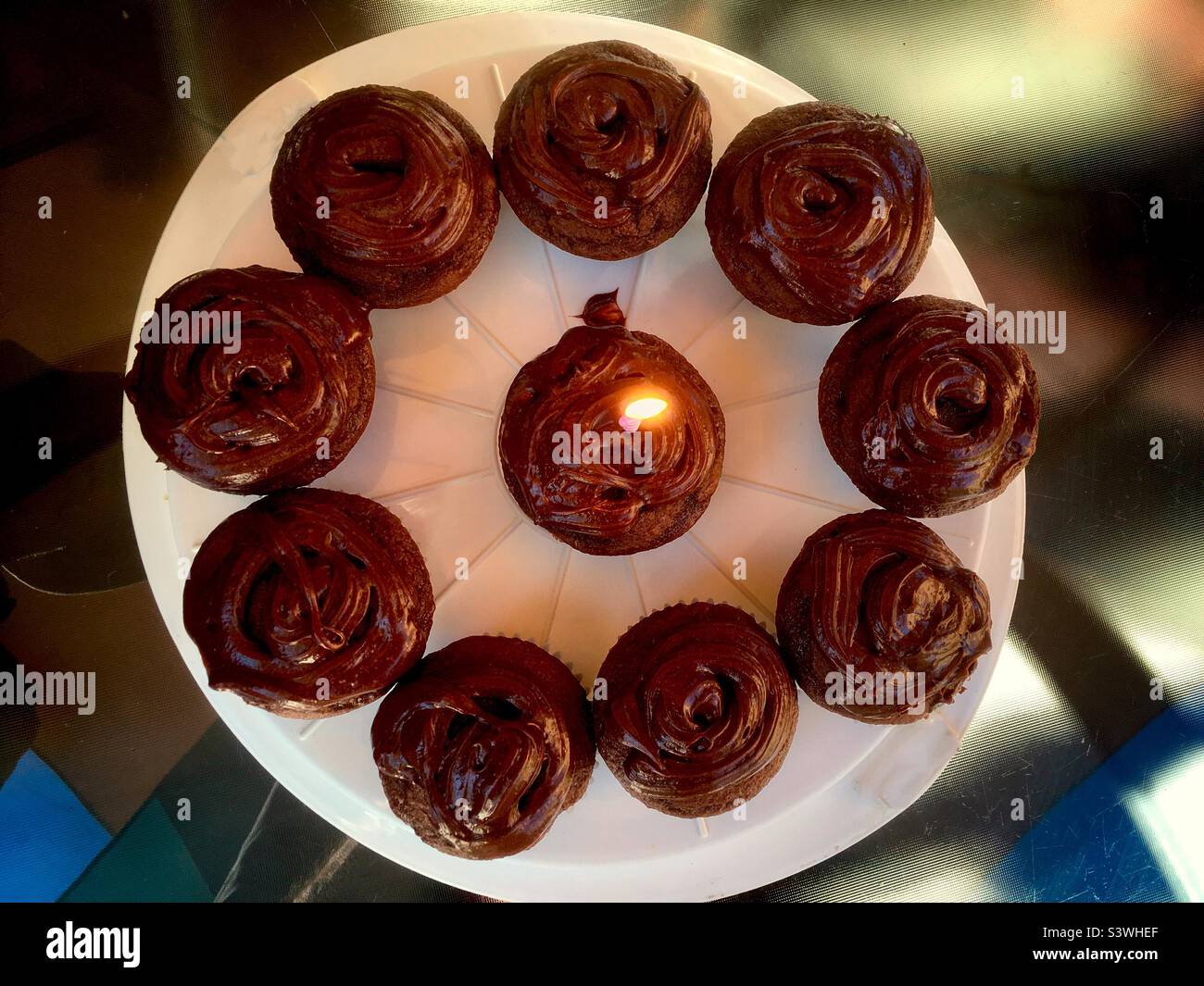 Geburtstagsfeier, Cupcakes und Kerze. Feiern. Elf Kreise. Übersichtlich angeordnet. Feiern Sie alle Geburtstage, jung und nicht so jung. Radiale Linien. - Smartphone-aufgenommenes Stockfoto