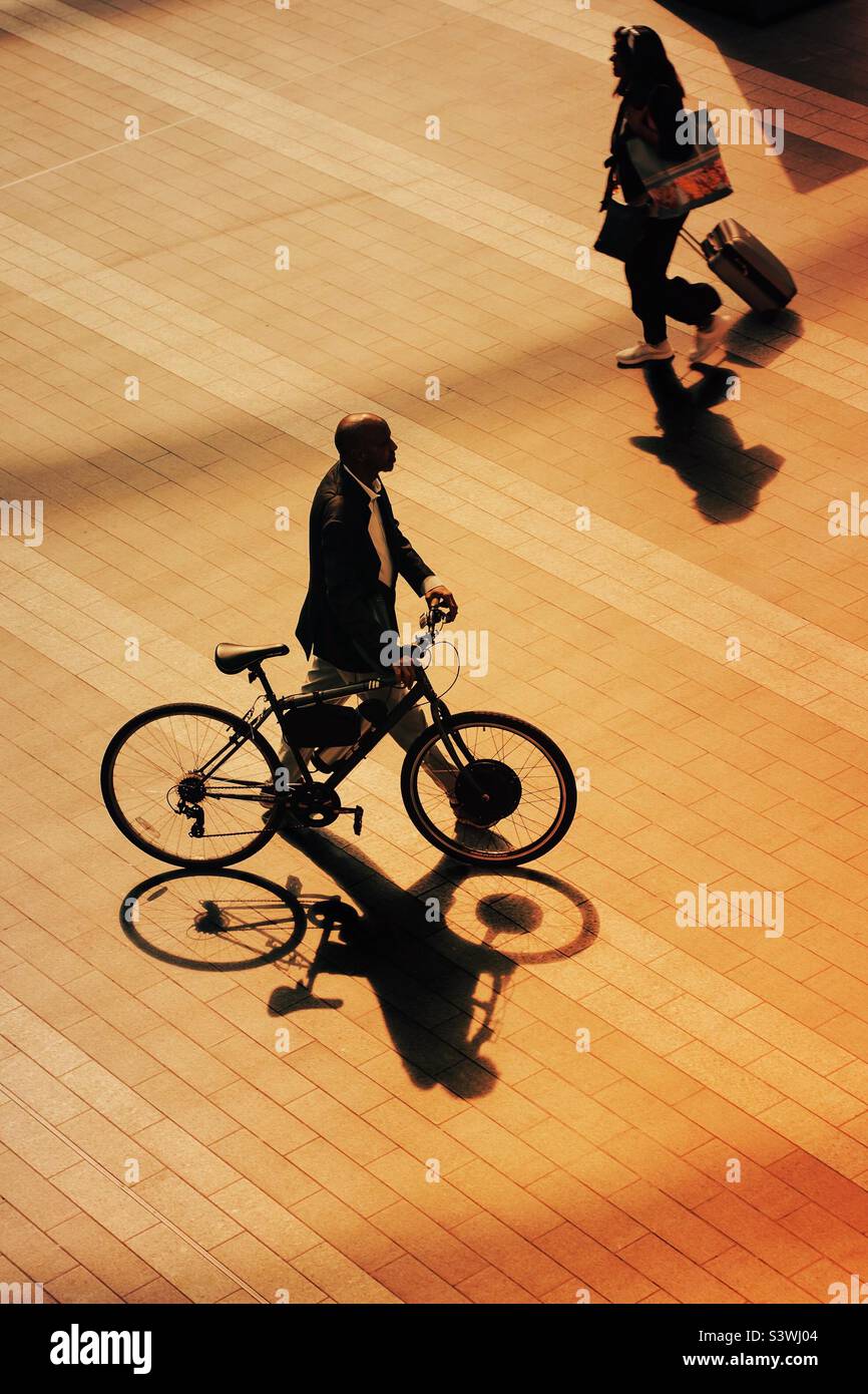 Ariel Blick auf Mann mit Fahrrad und Mädchen mit Koffer auf einer Reise in den frühen Morgenlicht Stockfoto