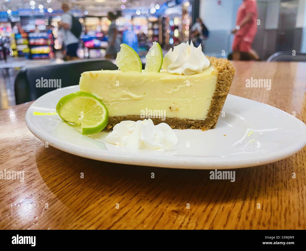 Ein Stück Keylim-Kuchen auf einem weißen Teller in einem Restaurant im Terminal D des Flughafens von Miami, Florida, USA - Smartphone-aufgenommenes Stockfoto