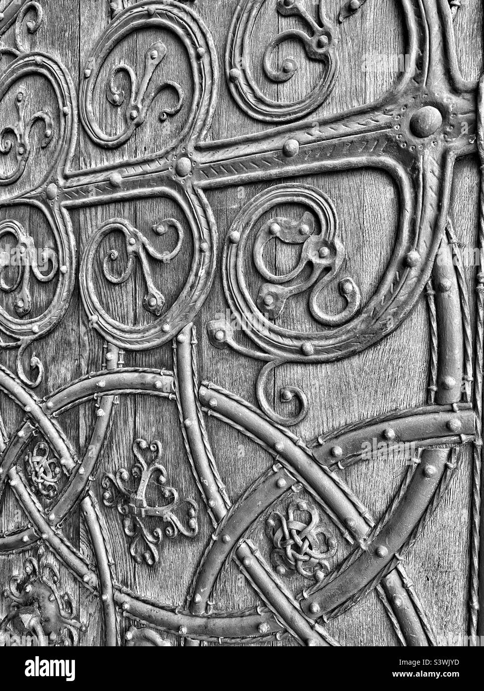 Ein monochromes Bild mit einigen Details der Great West Doors der Rochester Cathedral in Kent, England, Großbritannien. Diese denkmalgeschützte, dicke Holz- und Metalltür der Klasse 1 ist ein Kunstwerk. Foto ©️ COLIN HOSKINS. Stockfoto