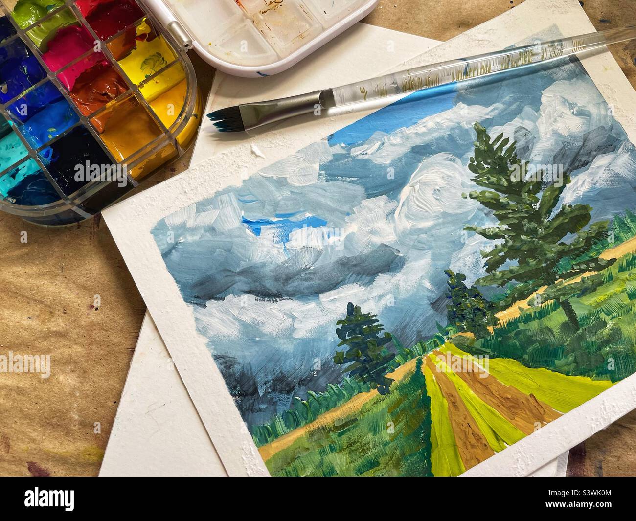Gouache Landschaftsmalerei mit einem Pinsel und einer Gouache-Palette. Stockfoto