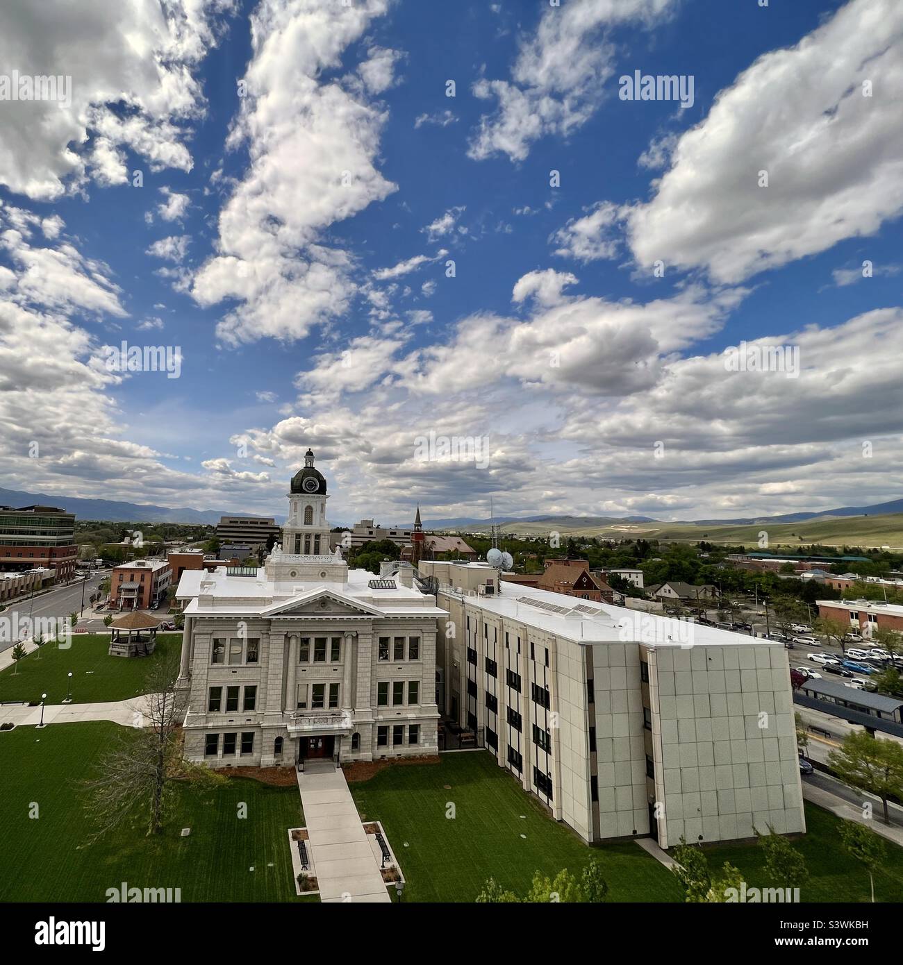 MISSOULA, MT, MAI 2022: Hoher Aussichtspunkt zeigt das Missoula County Courthouse, zusammen mit der Straße, den nahegelegenen Gebäuden und dem Bandstand auf dem Rasen, an bewölktem Tag Stockfoto