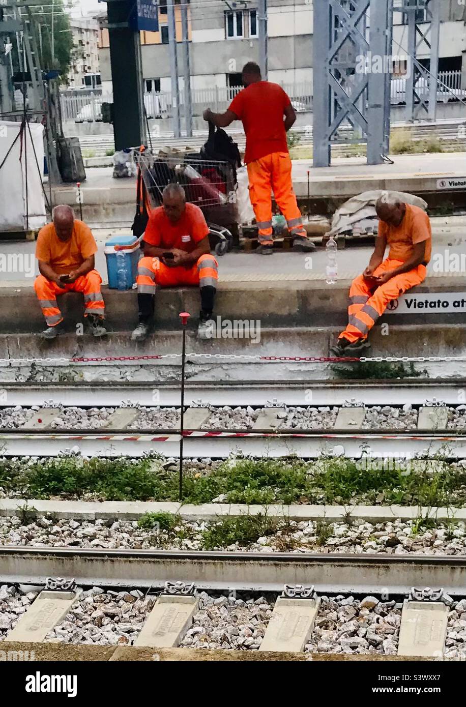 Eines arbeitet und drei checken ihre Handys in Brescia, Italien - Smartphone-aufgenommenes Stockfoto