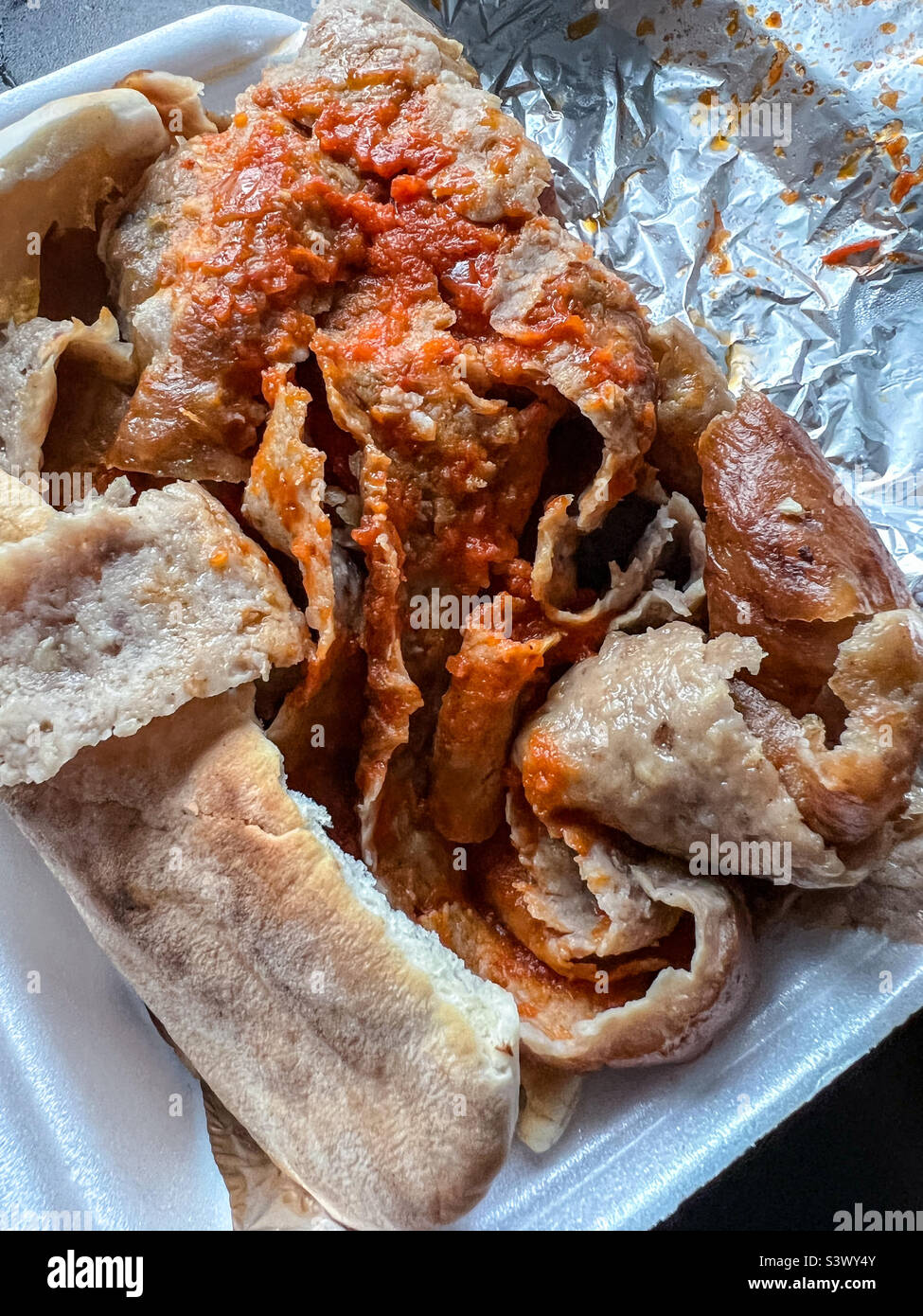 Döner Kebab in Pitta-Brot und Chilisauce Stockfoto