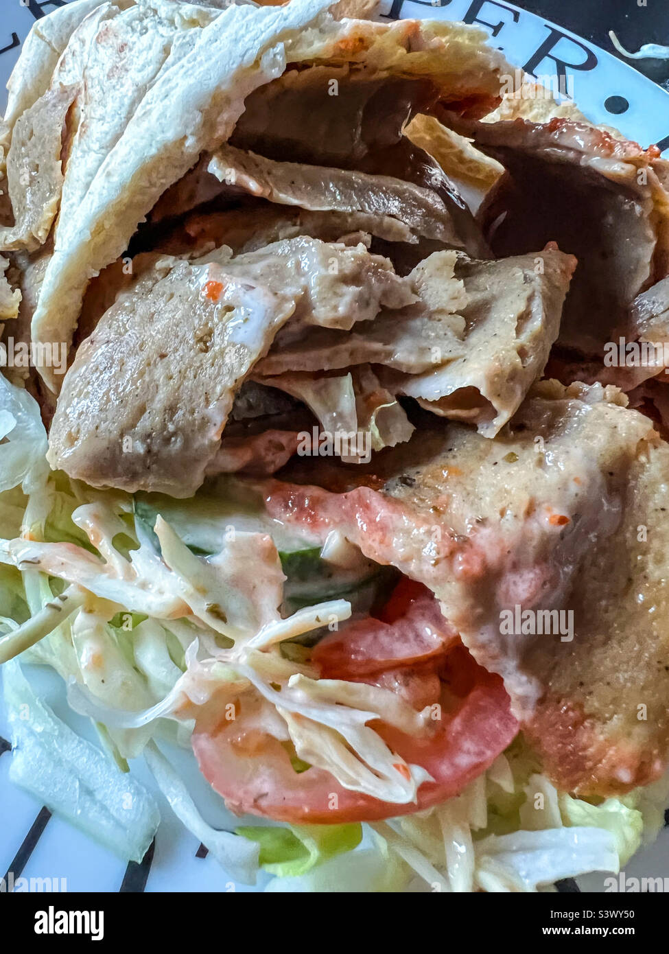 Döner Kebab in Pitta-Brot mit Salat und Chilisauce Stockfoto