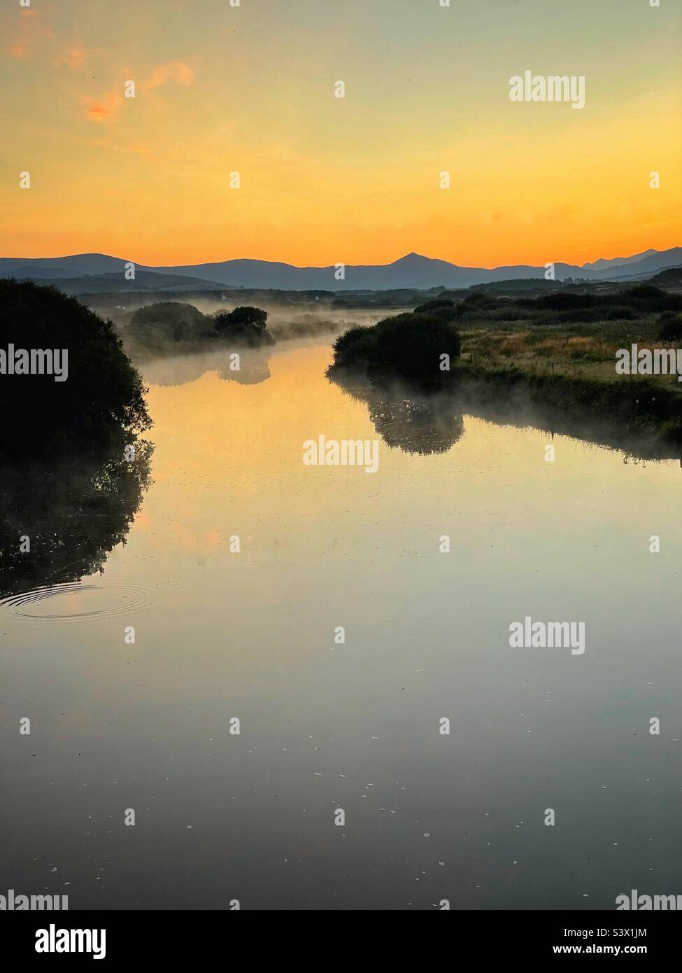 River Inny Mündung in der Nähe von Waterville , County Kerry, Irland, Blick landeinwärts in Richtung Macgillycuddy's Reeks, Morgendämmerung, August. - Smartphone-aufgenommenes Stockfoto