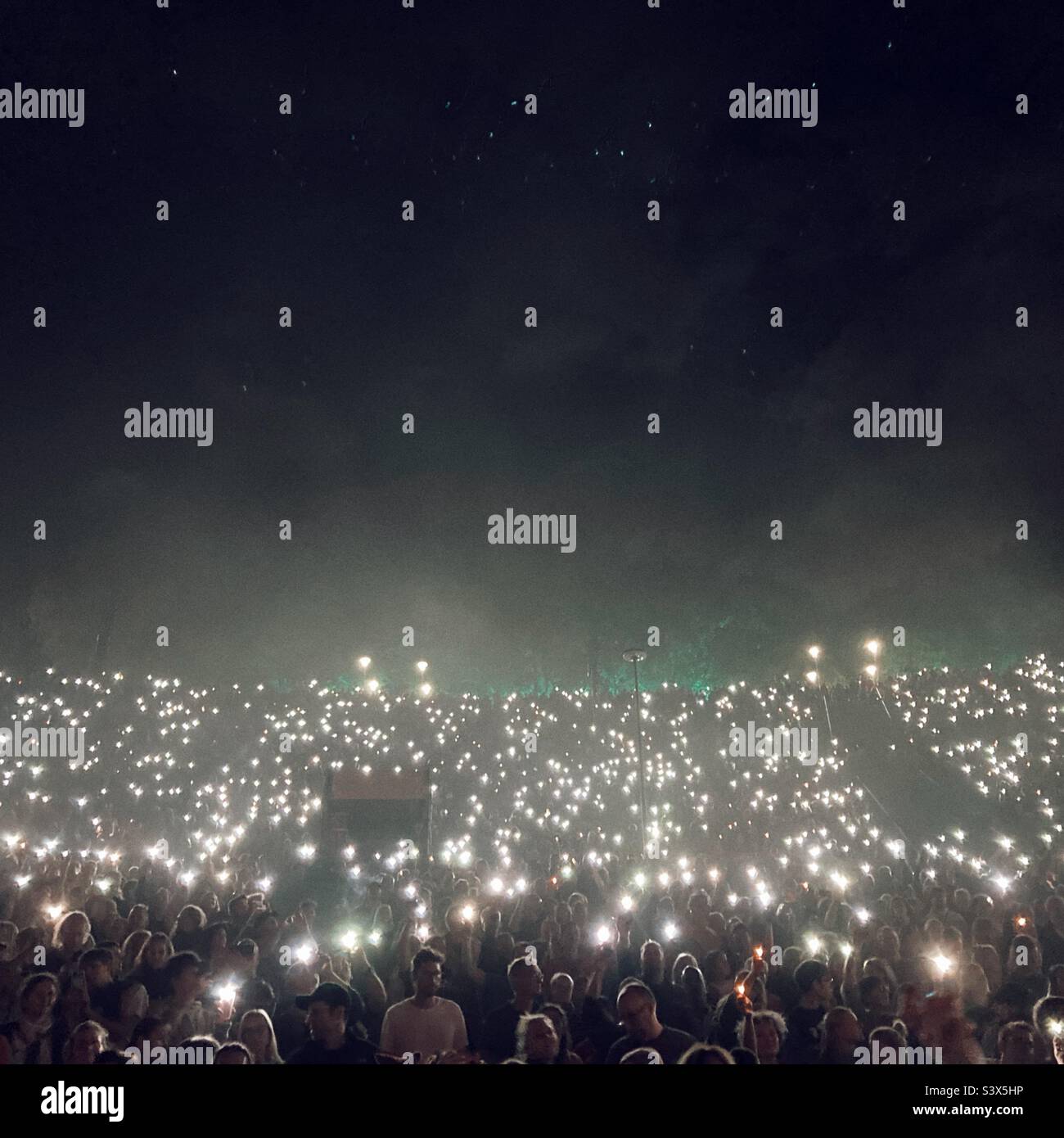 Publikum bei einem Popkonzert in der Berliner Wuhlheite mit Handylampen Stockfoto