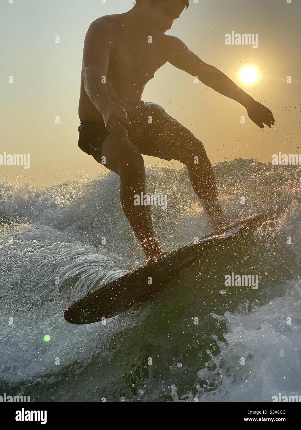 Surfen im Sonnenuntergang Stockfoto