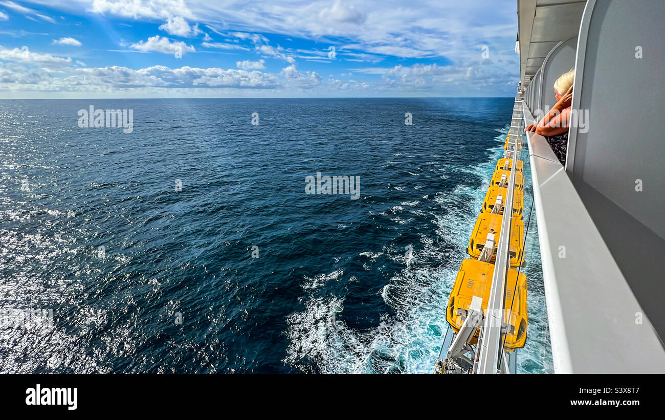 Frau, die im Sommer im Nordatlantik vom Balkon des Kreuzschiffs aus blickt Stockfoto