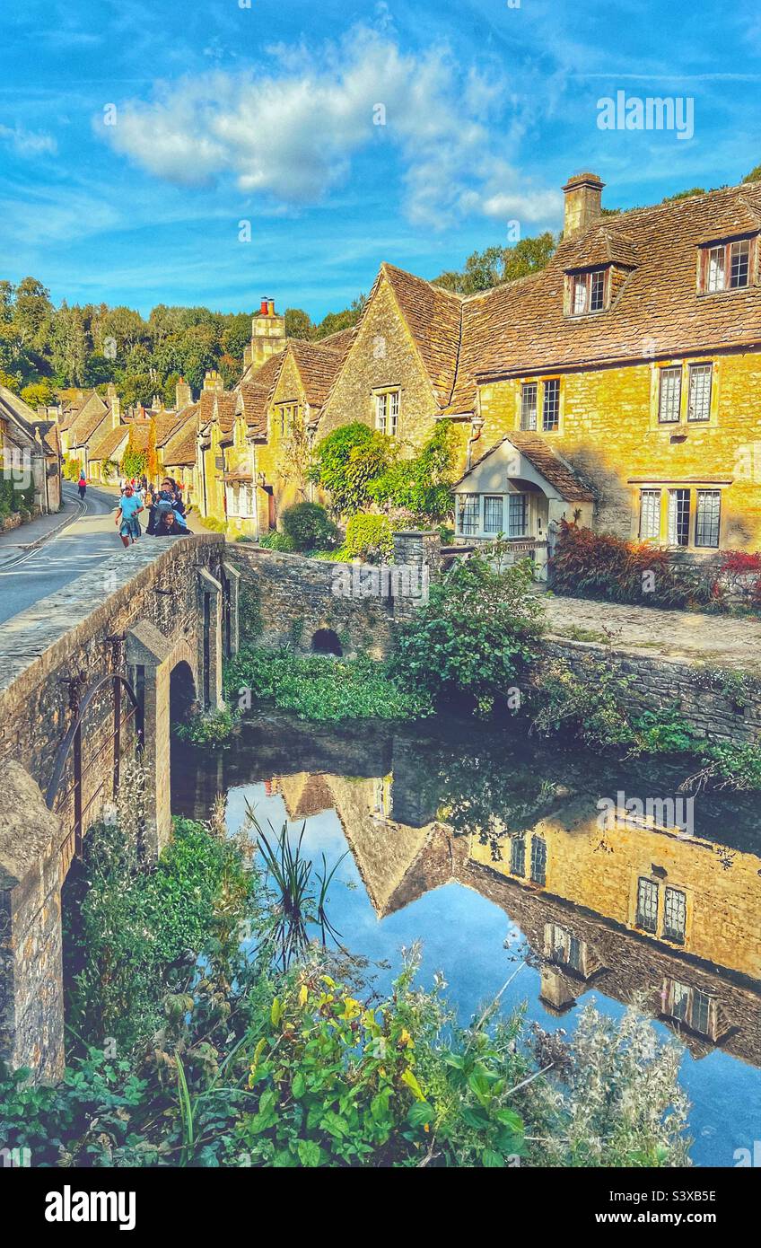 Dorf Castle Combe in Cotswolds Wiltshire, Blick über die Brücke mit den Häusern, die sich im Bybrook River spiegeln - Smartphone-aufgenommenes Stockfoto