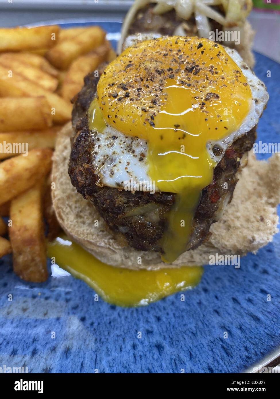 Hausgemachte Burger-Slider mit laufendem Ei - Smartphone-aufgenommenes Stockfoto