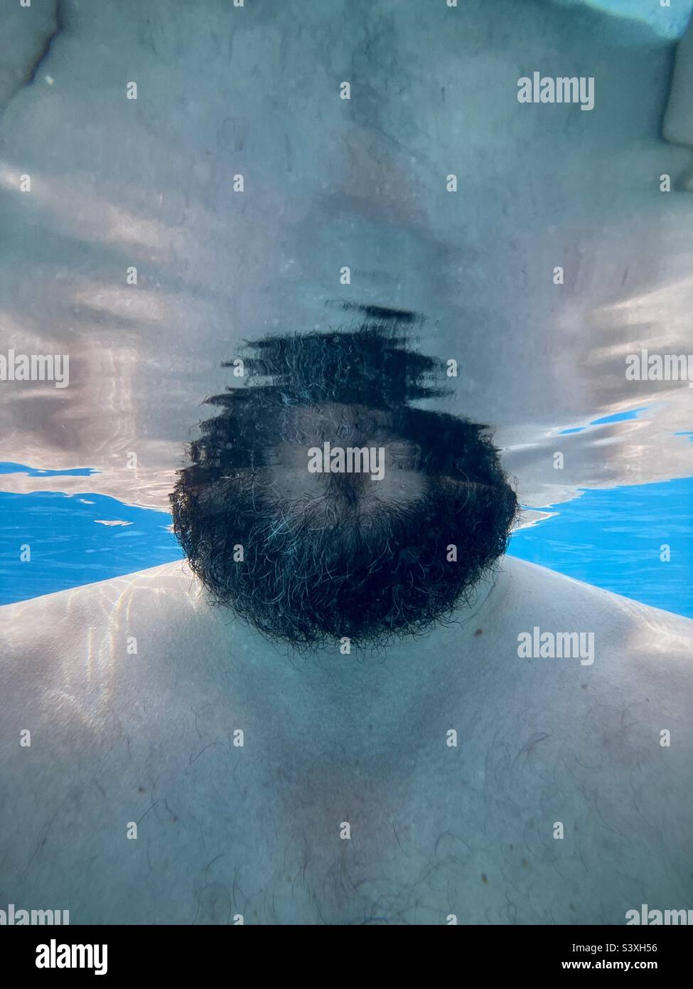 Abstraktes Unterwasserfoto des bärtigen Mannes Stockfoto