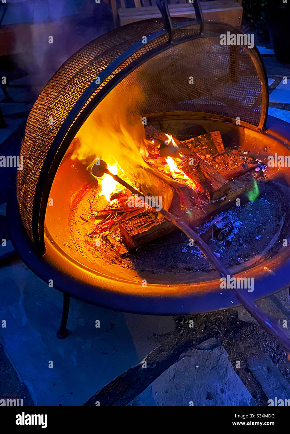 Braten von Marschmalow über einem offenen Feuer Stockfoto