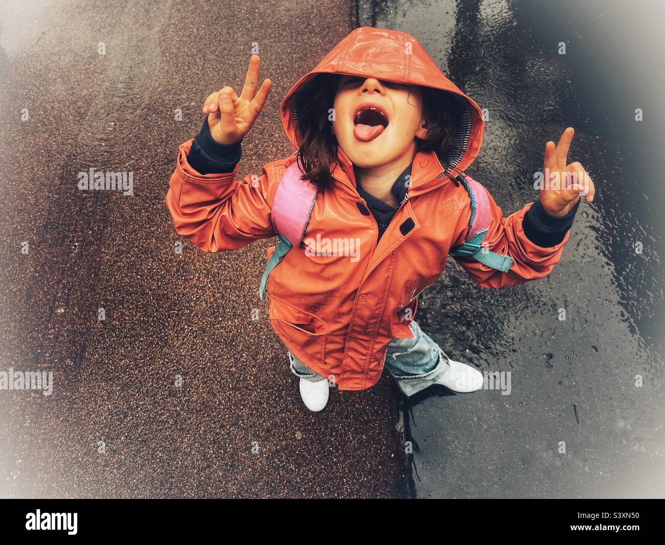 Glückliche Kinder, die im Regen spielen Stockfoto