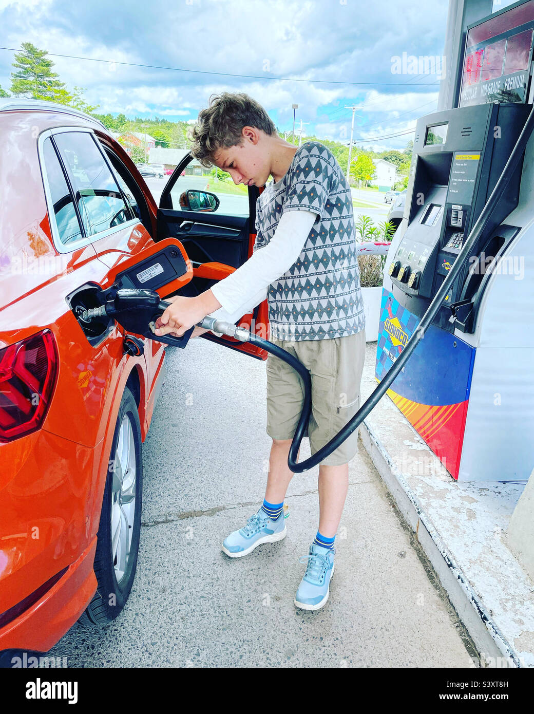 Junge füllt Auto mit Gas Stockfoto