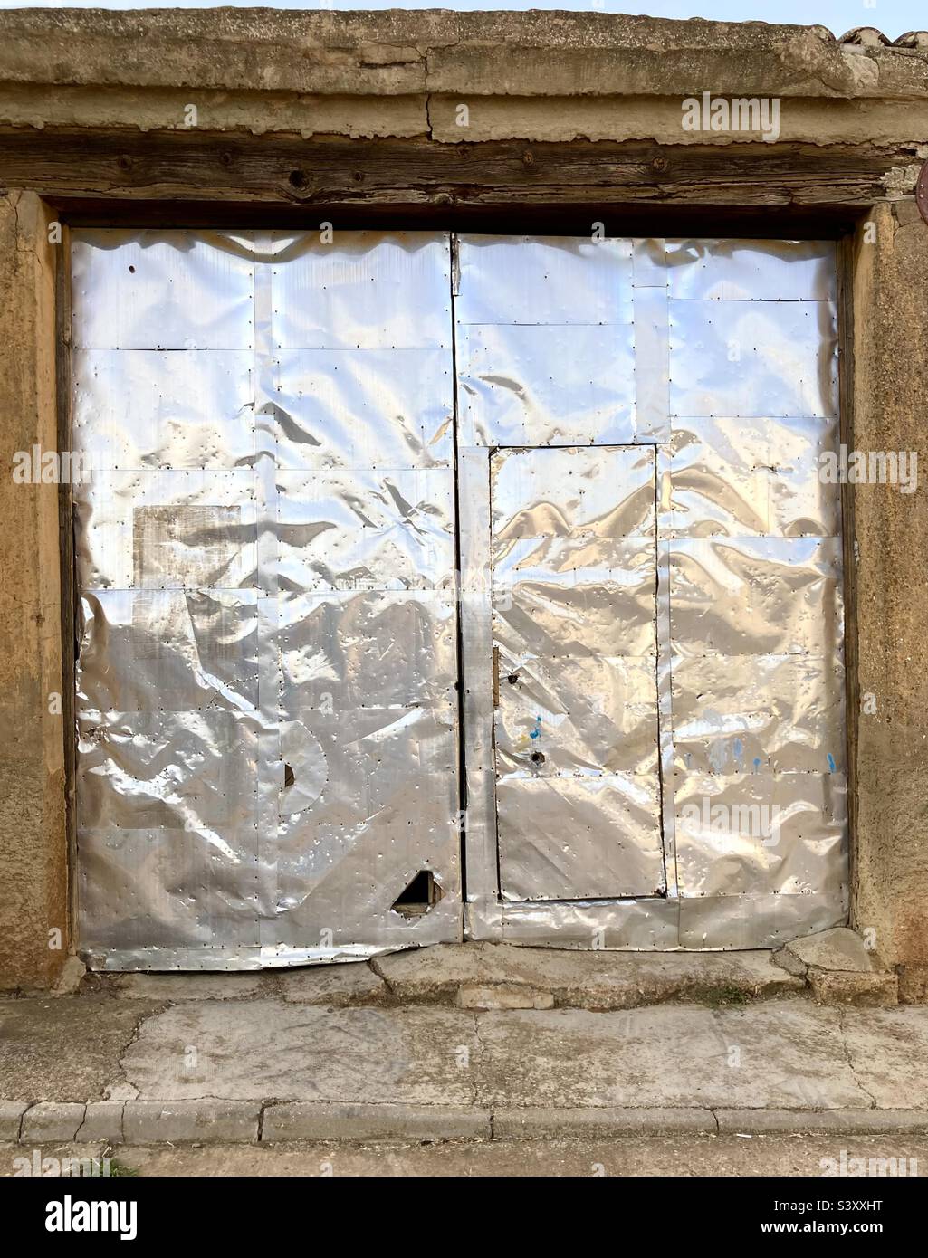 Große Scheunentüren aus Aluminium, Metallhaut, in einem Dorf in Spanien - Smartphone-aufgenommenes Stockfoto