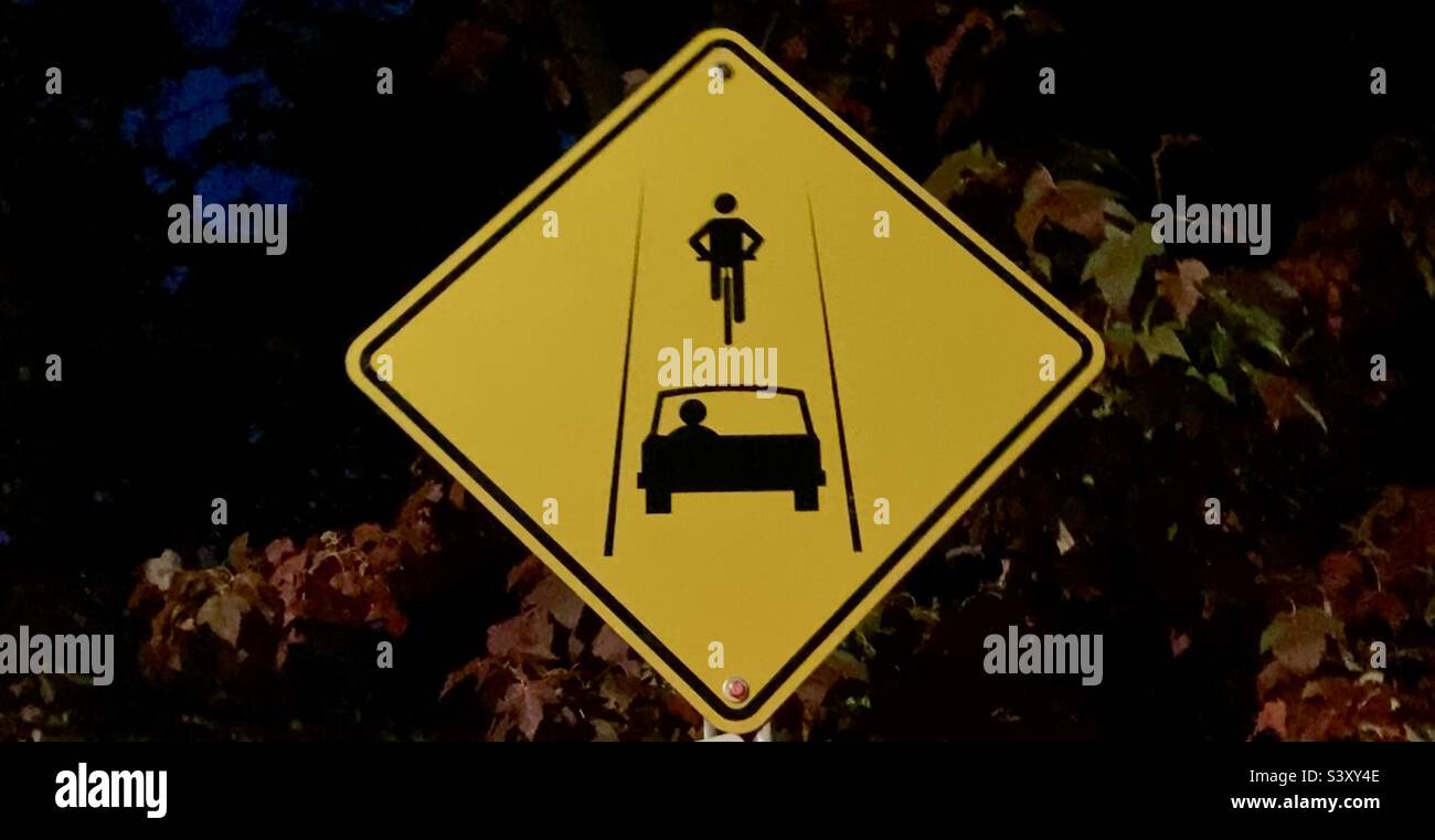 Ein gelbes Schild teilt sich das Straßenverkehrsschild. Stockfoto