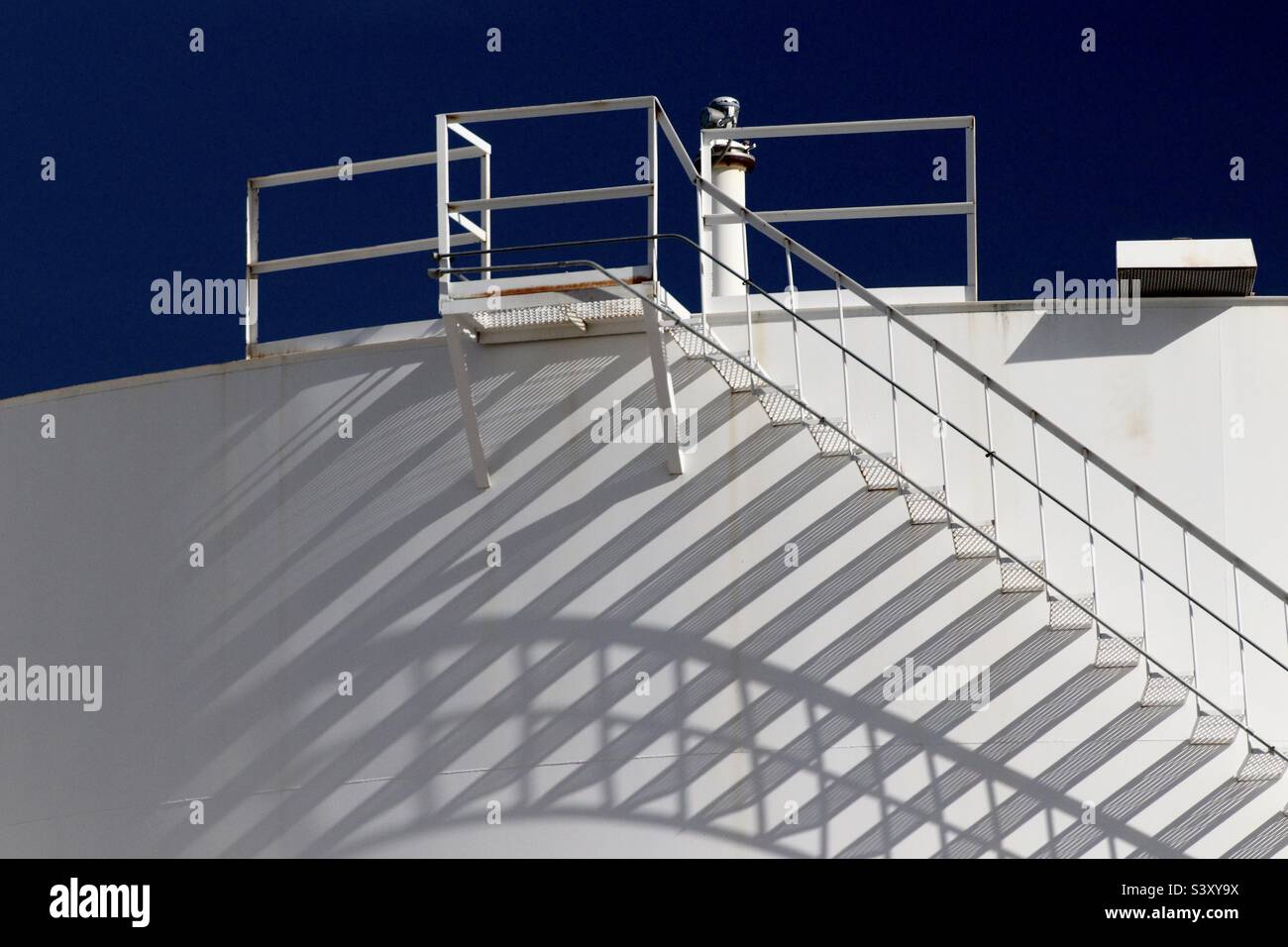 Cooles Schattenspiel auf diesem weißen Industriespeicher. Stockfoto