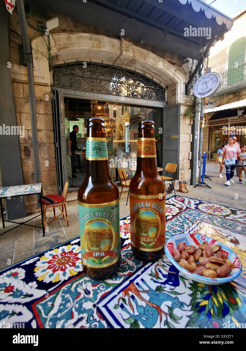 Genießen Sie das palästinensische Taybeh Bier im Abu ATA Zaman Café in der Nähe des Neuen Tores in der Altstadt von Jerusalem. Stockfoto