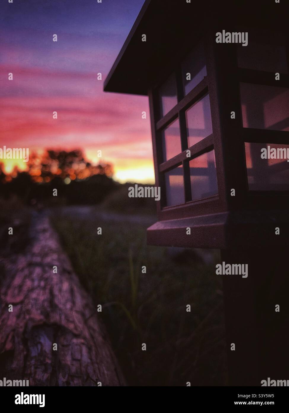 Solarleuchte mit Sonnenuntergang im Hintergrund - Smartphone-aufgenommenes Stockfoto