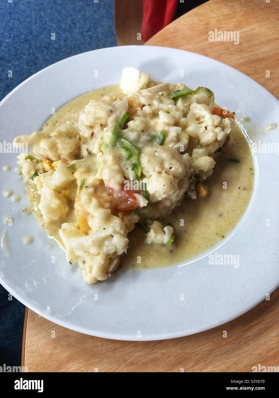 Ein Teller mit Essensresten, Blumenkohl, Reissuppe und Salat. Stockfoto