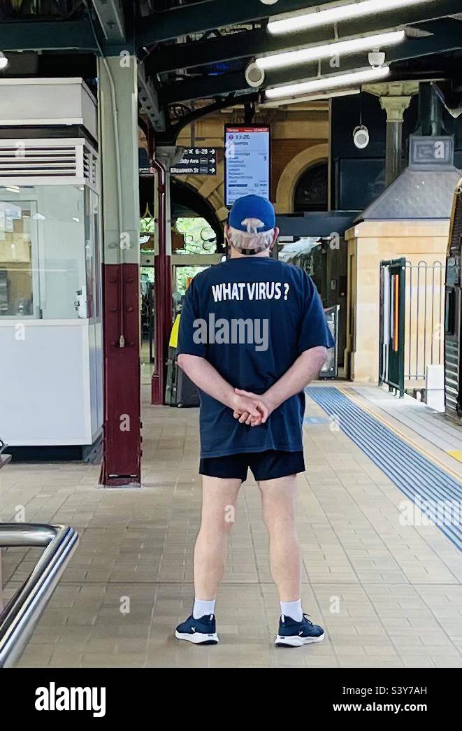 Mann mit einem What Virus T-Shirt auf einem Bahnhofssteig Stockfoto
