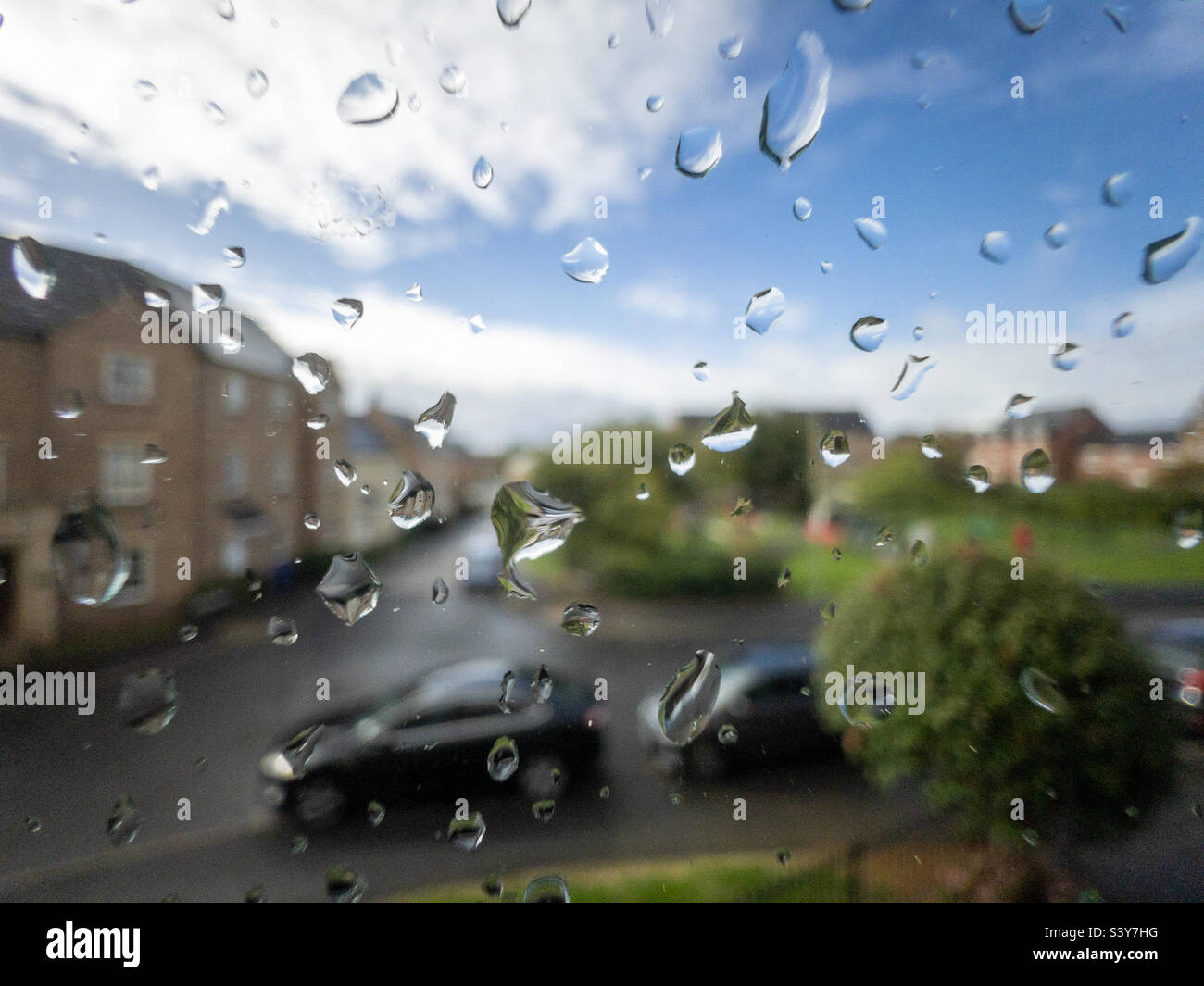 Regentropfen auf einem Fenster mit Blick auf die Straße Stockfoto
