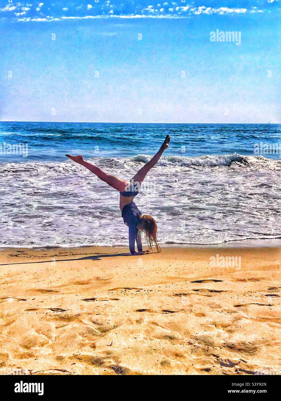 Junges Mädchen Turnen am Strand Stockfoto