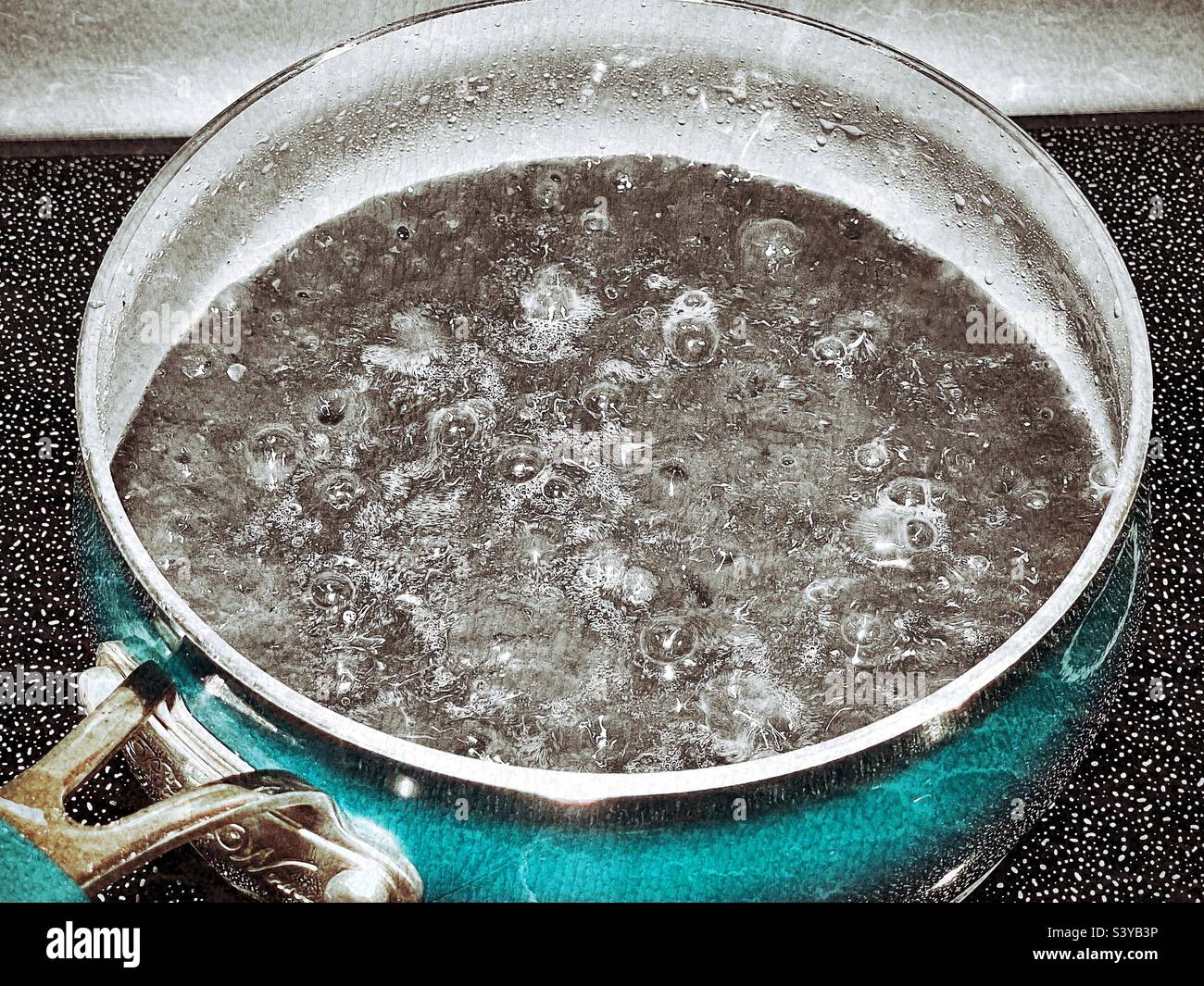 Am Thanksgiving-Tag in einer Küche in Utah, USA, kocht die kochende braune Soße auf einem Kochfeld. Farbauswahl und Grunge-Effekte aus künstlerischen Gründen digital hinzugefügt. - Smartphone-aufgenommenes Stockfoto