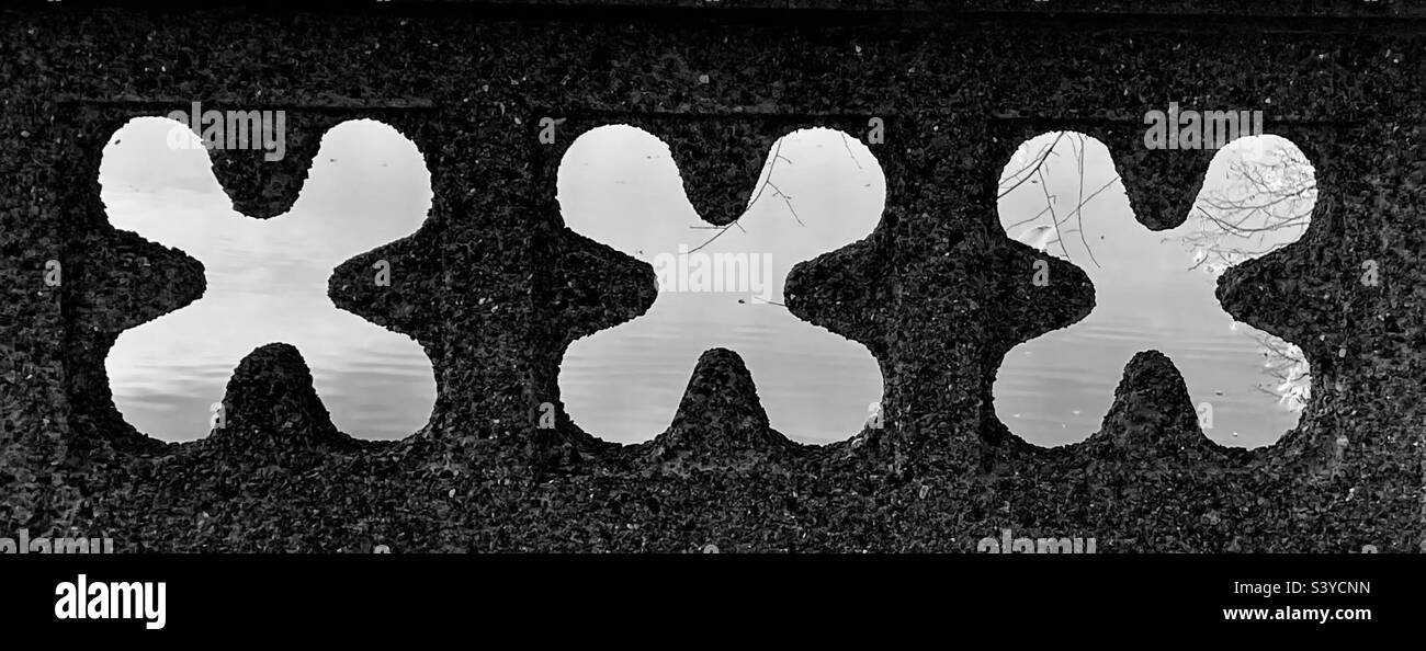 X-förmige Designs in einer zerkleinerten Steinwand. - Smartphone-aufgenommenes Stockfoto