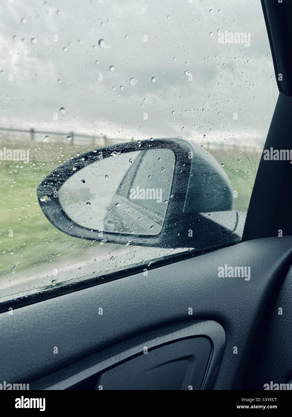 Nasse Auto Außenspiegel. Rückspiegel eines Autos durch die  Windschutzscheibe im Regen. Regen fällt auf das Auto Glas Fenster  Stockfotografie - Alamy
