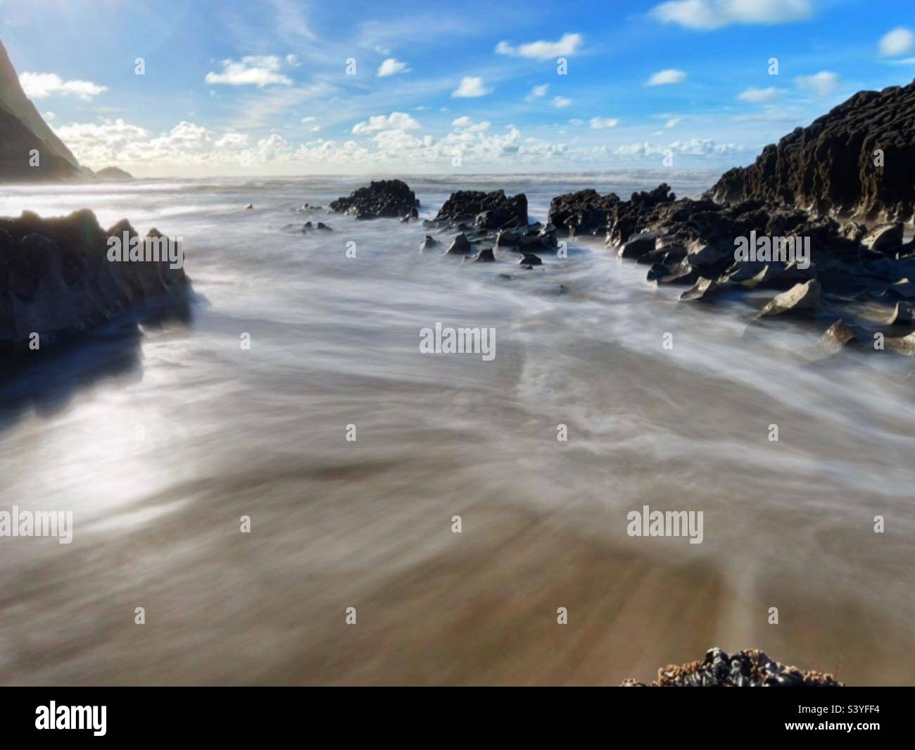 Wellen, die sich durch die Felsen am Mewslade Beach, Gower, Swansea, Wales, waschen. Stockfoto