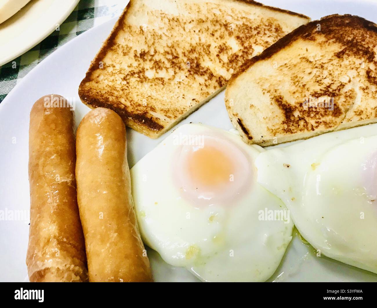Frühstück mit Würstchen, Eiern und gebratenem Brot Stockfoto