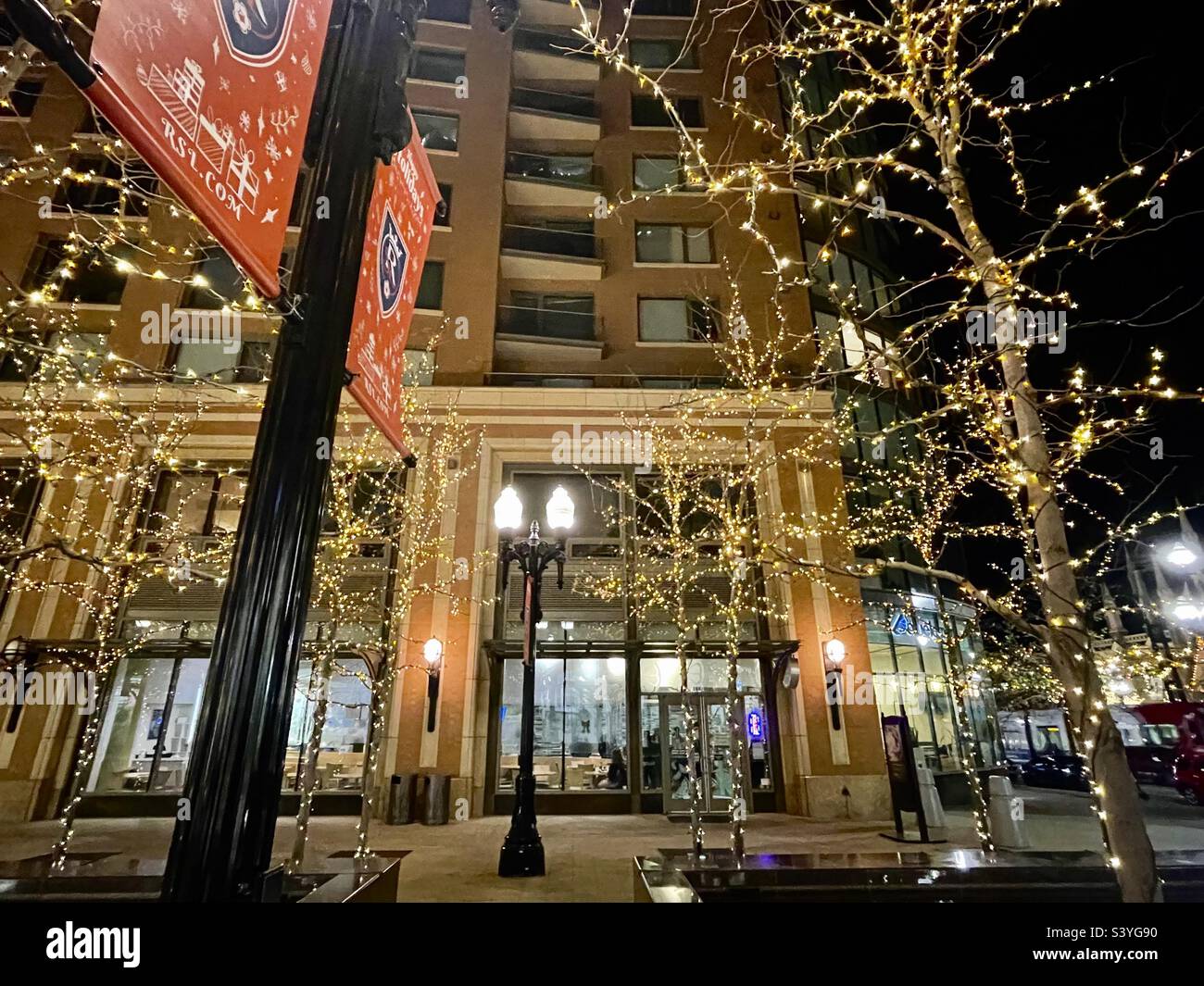 Das City Creek Shopping Center in der Innenstadt von SLC Utah, USA während der Weihnachtszeit. Unter den Lichtern hängen auch festliche rote RSL-Banner, gesponsert von der örtlichen Fußballmannschaft „Real Salt Lake“. - Smartphone-aufgenommenes Stockfoto