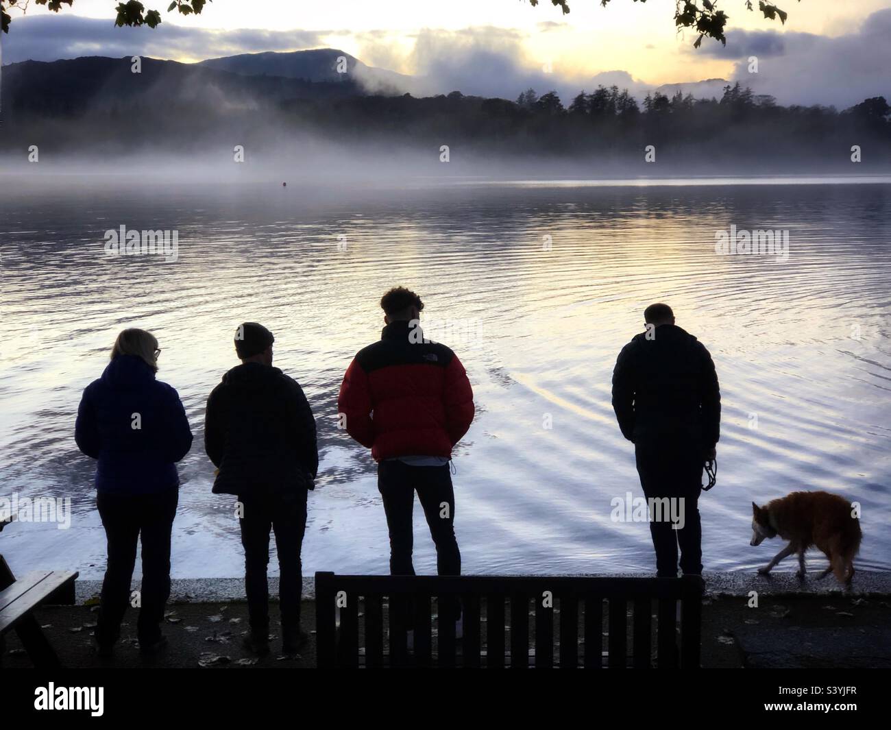 Menschen am Ufer des Lake Windermere in der Abenddämmerung, Cumbria Lake District Stockfoto