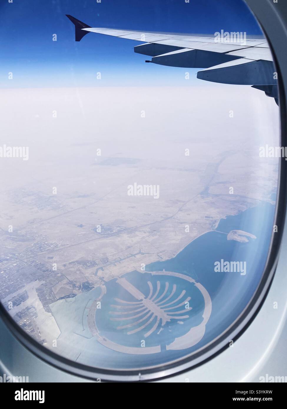 Blick durch ein Flugzeugfenster auf Palm Jumeirah, eine baumförmige künstliche Insel in Dubai. Stockfoto