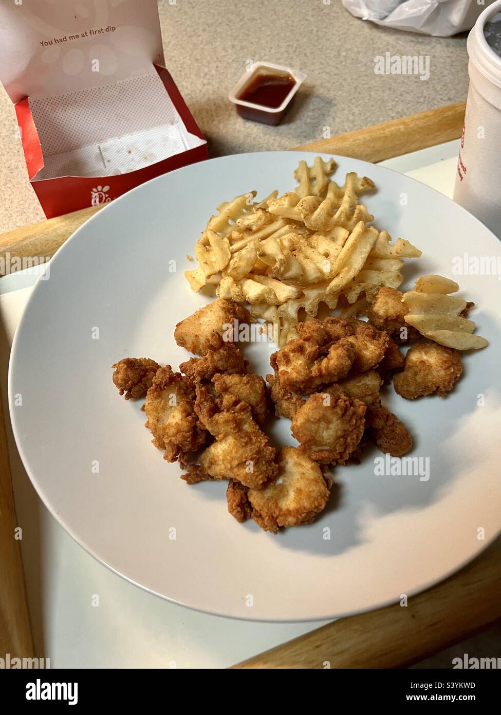 12-teilige Hähnchennuggets mit Waffelfritten. Bin ich es oder sieht das wie Hühnerkrümel aus? Preise höher, weniger Essen! Stockfoto