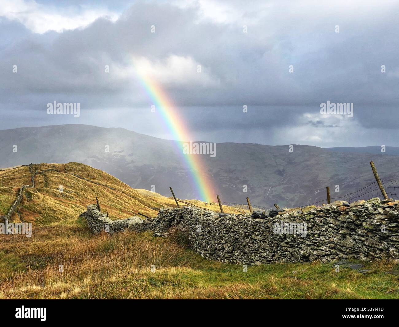Blick vom Gipfel des Wansfell Pike mit Regenbogen, Steindeiche und Zaun, Ambleside Lake District - Smartphone-aufgenommenes Stockfoto