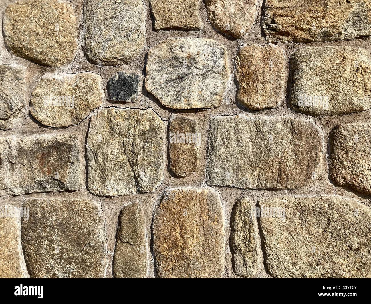 Steinwand mit Brauntönen als strukturierter Hintergrund Stockfoto