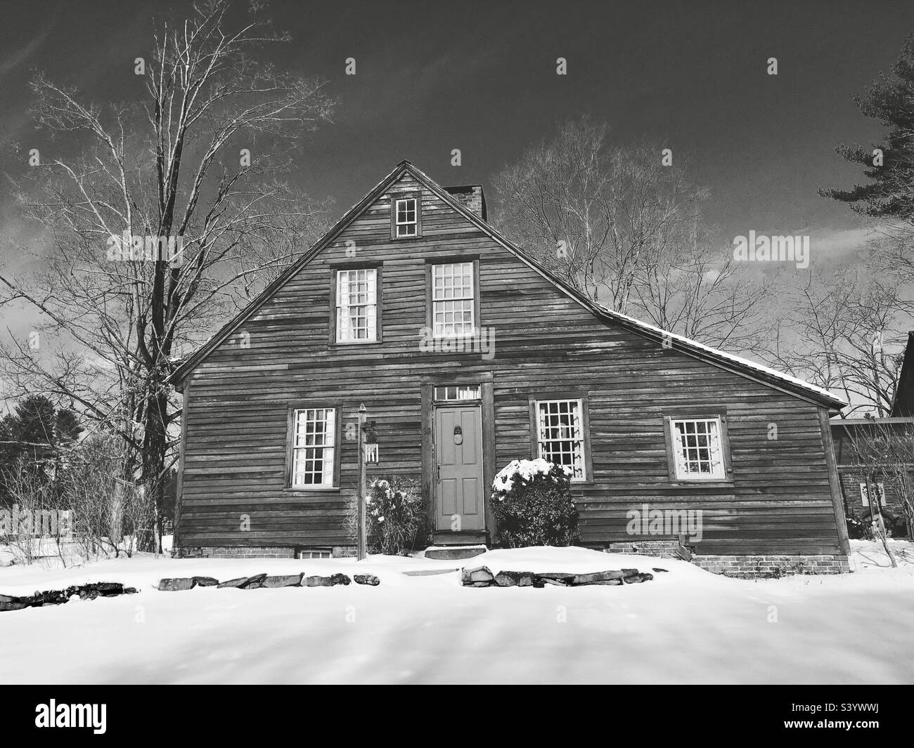 Glastonbury, Connecticut, USA - Dezember 2021: Der jüngste Schnee bedeckt den Boden und die Umgebung. Das Schwarzweißfoto zeigt ein altes Haus in New England in Glastonbury, Connecticut. (Redaktionell) - Smartphone-aufgenommenes Stockfoto
