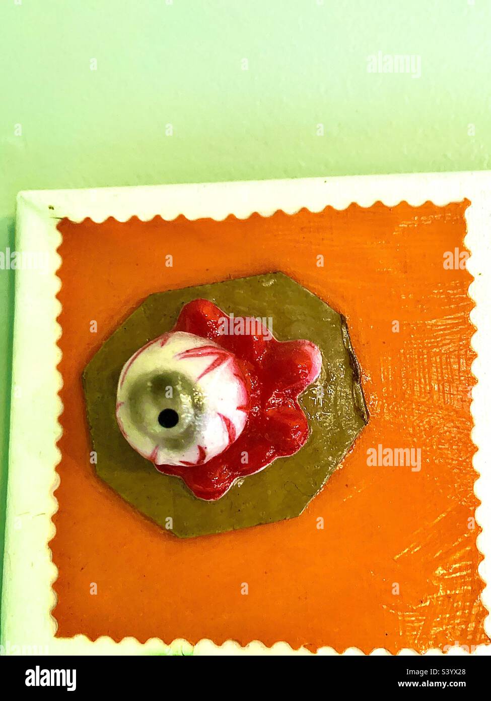 Gorey-Augapfel auf orangefarbenem und grünem Hintergrund mit Kopierbereich - Smartphone-aufgenommenes Stockfoto