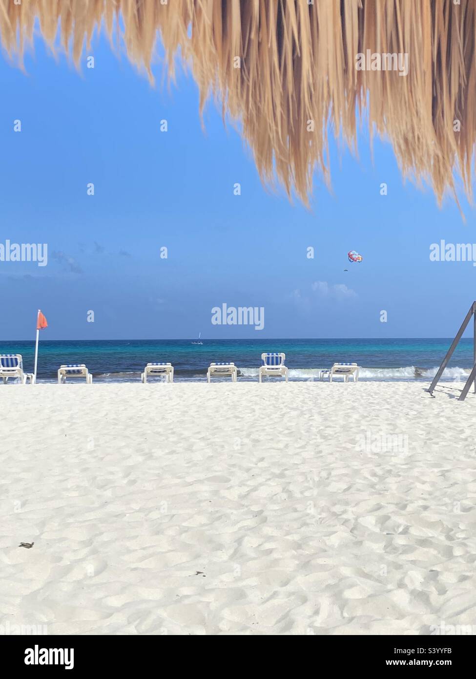 Sieht aus wie ein Paradies mit weißem Sand, blauem Ozean im Karibischen Meer, Cancun Mexiko, mit Liegestühlen und Sonnenliegen entlang der Küste Stockfoto